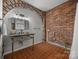 Industrial-style bathroom featuring exposed brick walls, vessel sink with exposed plumbing, and tile floors at 217 S Ellis St, Salisbury, NC 28144