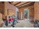 Unique workout room featuring exposed brick walls, exercise bike, shelving and an exterior door to stairs at 217 S Ellis St, Salisbury, NC 28144