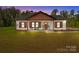 Charming single-story home with covered porch, rocking chairs, manicured lawn and beautiful natural surroundings at 2220 Mooresville Rd, Salisbury, NC 28147