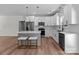 Well-lit open kitchen with white cabinets, stainless appliances, island seating and hardwood floors at 2220 Mooresville Rd, Salisbury, NC 28147