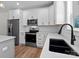 Open kitchen with stainless steel appliances, modern fixtures, white cabinets, quartz counters and hardwood floors at 2220 Mooresville Rd, Salisbury, NC 28147