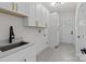 This is the laundry room with a sink, cabinets, and a tiled floor with access to the backyard at 2220 Mooresville Rd, Salisbury, NC 28147