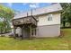 View of the house's backyard featuring a wooden deck, lawn and basement access via double doors at 223 Tennessee Trl, Lincolnton, NC 28092