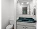 A compact bathroom with green sink, a toilet, and a decorative wall mirror at 223 Tennessee Trl, Lincolnton, NC 28092