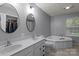 A neutral bathroom with a double sink vanity, soaking tub, and tiled floors at 223 Tennessee Trl, Lincolnton, NC 28092