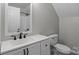 Functional bathroom with a white vanity, sink, mirror, and a toilet in a clean and simple design at 223 Tennessee Trl, Lincolnton, NC 28092