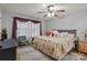 A cozy bedroom with a floral bedspread, wood ceiling fan, and bright natural light at 223 Tennessee Trl, Lincolnton, NC 28092