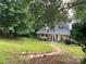 Inviting home exterior featuring a charming front porch, lush lawn, and landscaped walkway at 223 Tennessee Trl, Lincolnton, NC 28092