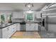 A bright kitchen features stainless steel appliances, white cabinets, and modern lighting at 223 Tennessee Trl, Lincolnton, NC 28092