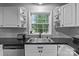 Well-lit kitchen sink area featuring sleek faucet, white cabinets and a window overlooking the backyard at 223 Tennessee Trl, Lincolnton, NC 28092