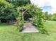 Lush backyard garden with a wooden arbor covered in greenery at 2325 Perry Rd, Denver, NC 28037