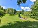 Spacious backyard with mature trees and a fire pit seating area at 2325 Perry Rd, Denver, NC 28037