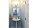Small, well-lit bathroom with pedestal sink and decorative mirror at 2325 Perry Rd, Denver, NC 28037
