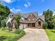 Beautiful brick home with a three-car garage and a meticulously maintained front yard with landscaping at 2325 Perry Rd, Denver, NC 28037