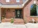 Close-up of the front door and entrance of a beautiful brick home with decorative details and landscaping at 2325 Perry Rd, Denver, NC 28037