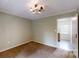Bedroom with light green walls, carpeted floors, and chandelier lighting, with an open doorway to the rest of the house at 2507 Birnen Dr, Charlotte, NC 28210