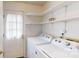 Bright laundry room featuring white washer, dryer, and shelving at 2507 Birnen Dr, Charlotte, NC 28210