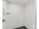 Modern bathroom featuring sleek white tile walls and a stylish black honeycomb-tiled shower floor at 2517 Marlowe Ave, Charlotte, NC 28208