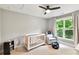 Charming Bedroom features a ceiling fan, crib, cozy chair, and natural light from the window at 2517 Marlowe Ave, Charlotte, NC 28208
