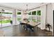 Sunlit dining room with an elegant light fixture, windows to yard, and hardwood floors at 2517 Marlowe Ave, Charlotte, NC 28208