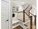 Entryway with storage and a bench adjacent to stairs with wood trim and white risers and balusters at 2517 Marlowe Ave, Charlotte, NC 28208