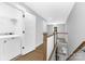 Hallway landing with a laundry area, wood railing, and carpeted stairs at 2517 Marlowe Ave, Charlotte, NC 28208