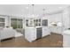 Modern kitchen with a large island, stainless steel appliances, white cabinets, and opens to living area at 2517 Marlowe Ave, Charlotte, NC 28208