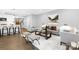 Open-concept living area with seating, kitchen access, stairs, and hardwood floors at 2517 Marlowe Ave, Charlotte, NC 28208