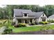 Charming two-story home with landscaped yard, covered porch and modern farmhouse details on a lush green lawn at 2656 Lee Lawing Rd, Lincolnton, NC 28092
