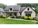Beautiful landscaped lawn with covered front porch and modern farmhouse design elements at 2656 Lee Lawing Rd, Lincolnton, NC 28092