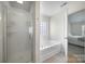 Bright bathroom featuring a glass-enclosed shower and a soaking tub with tile surround at 3015 Liddington Rd, Matthews, NC 28105