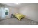 Bright bedroom with a single bed, a window, neutral walls, and carpet flooring at 3015 Liddington Rd, Matthews, NC 28105