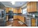 Well-lit kitchen boasts stainless steel appliances, wood cabinets, and luxury vinyl plank flooring at 3015 Liddington Rd, Matthews, NC 28105