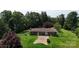 Aerial showcasing the home's brick exterior, set amidst verdant lawns and mature trees, a peaceful retreat at 3151 Lynn Mountain Rd, Vale, NC 28168