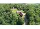 Expansive aerial view showcasing a home with a barn and long driveway nestled among lush greenery and mature trees at 3151 Lynn Mountain Rd, Vale, NC 28168