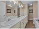Spacious bathroom featuring double sinks with white cabinets and a large, well-lit mirror at 350 Moose Dr, Stony Point, NC 28678