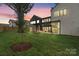 Spacious backyard with lush green grass, a covered patio, and a modern home exterior at 3822 Topsfield Rd, Charlotte, NC 28211
