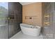 Modern bathroom featuring a standalone tub, mosaic tiled floors, and unique decorative elements at 3822 Topsfield Rd, Charlotte, NC 28211