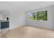 A well-lit room with hardwood floors, large windows, and an ensuite bathroom with blue tiled walls at 3822 Topsfield Rd, Charlotte, NC 28211