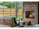 Cozy outdoor living space featuring a brick fireplace, comfortable seating, and a view of the backyard at 3822 Topsfield Rd, Charlotte, NC 28211