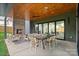 Covered patio with a fireplace, outdoor dining table, and comfortable seating area at 3822 Topsfield Rd, Charlotte, NC 28211