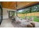 Covered patio with a ceiling fan, dining and lounge area, offering serene backyard views at 3822 Topsfield Rd, Charlotte, NC 28211