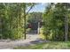 View of modern home's gravel driveway surrounded by mature trees and a sleek exterior design at 386 Squirrel Ln, Lake Wylie, SC 29710