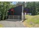 A modern home with black siding, red accents, a two car garage and a gravel driveway at 386 Squirrel Ln, Lake Wylie, SC 29710