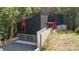 Contemporary home with sleek black exterior, red accents, driveway and a two-car garage at 386 Squirrel Ln, Lake Wylie, SC 29710