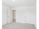 Neutral bedroom space with plush carpeting, bright white walls, and two doors at 401 W Charlotte Ave, Mount Holly, NC 28120