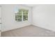 A sunny bedroom with plush carpeting, and a large window at 401 W Charlotte Ave, Mount Holly, NC 28120