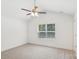 Spacious bedroom featuring plush carpeting, a ceiling fan, and a large window with natural light at 401 W Charlotte Ave, Mount Holly, NC 28120