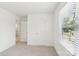Clean bedroom space offering neutral carpeting, bright white walls, and a sunlit window view at 401 W Charlotte Ave, Mount Holly, NC 28120