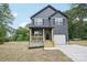 Two-story home featuring a charming front porch, a garage, and modern siding at 401 W Charlotte Ave, Mount Holly, NC 28120